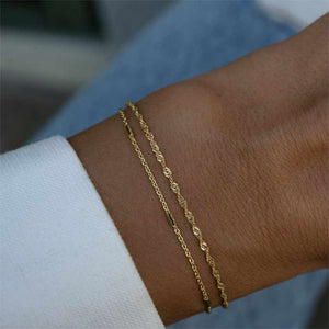 zierliche Forever Bracelets in Gold am Arm einer glücklichen Kundin